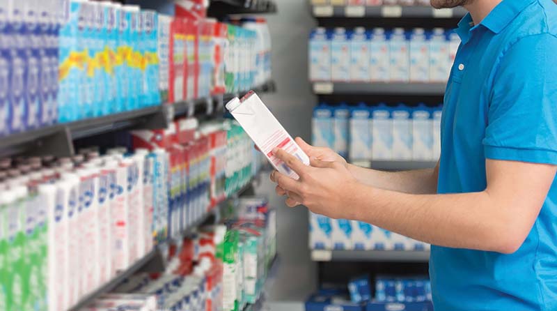 Handsome Young Man Shopping For Milk And Cheese In Produce Department Of A Grocery Store - Supermarket - Shallow Deep Of Field
