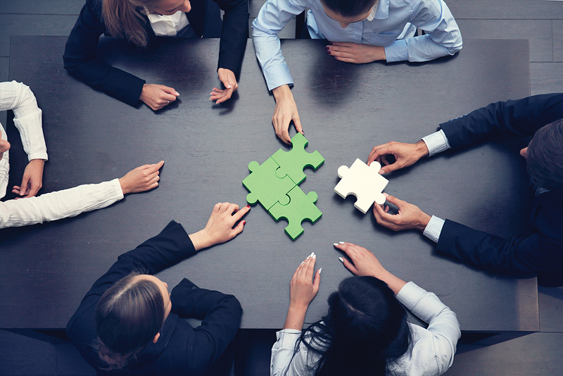 Group of business people assembling jigsaw puzzle, team support and help concept