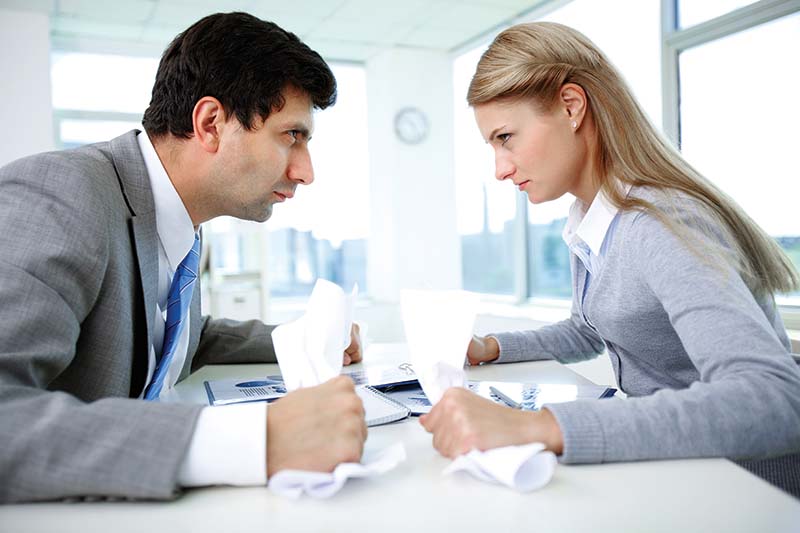 Profiles of angry employees with papers looking at each other strictly