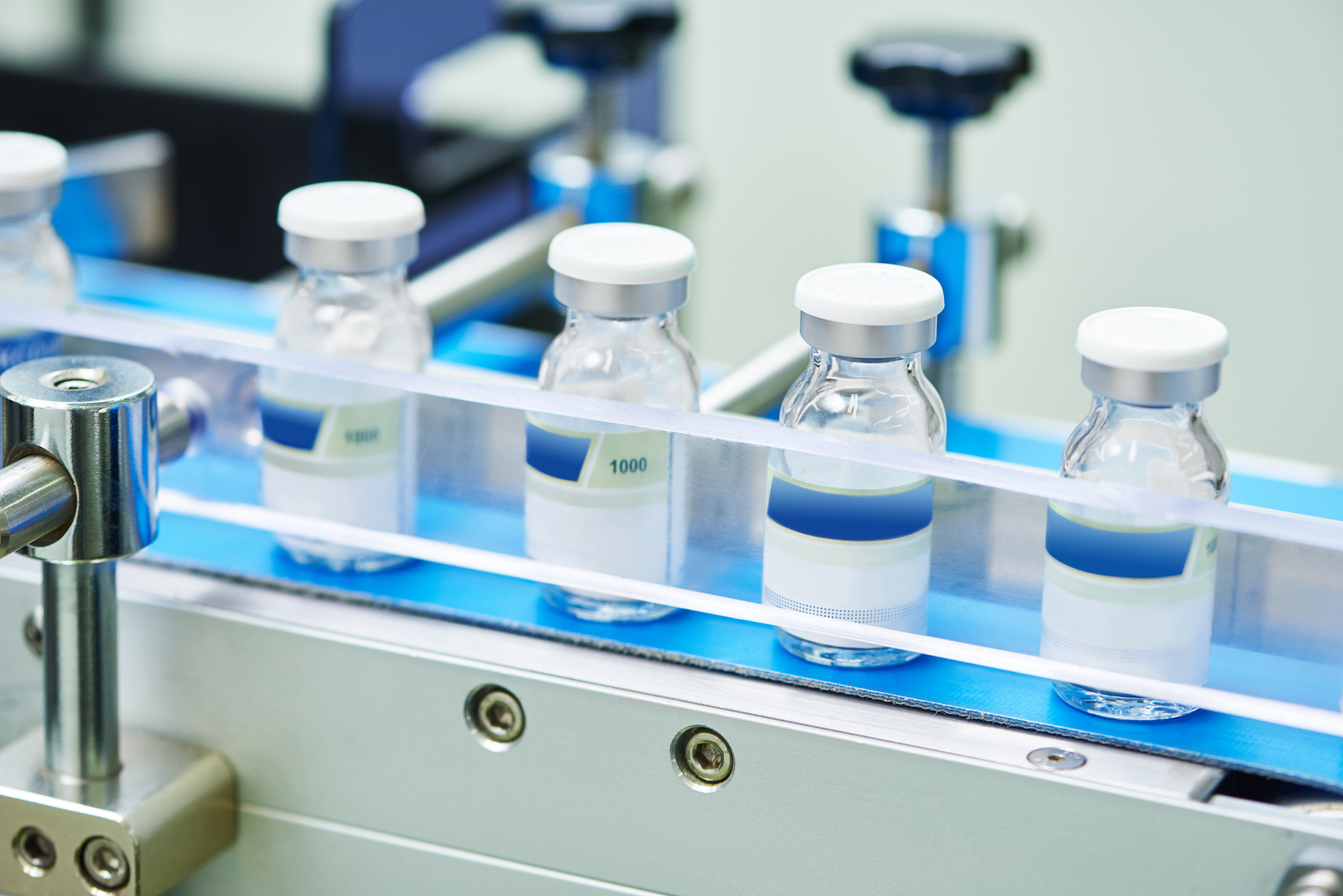 pharmaceutical industry. Production line machine conveyor with glass bottles ampoules at factory 
